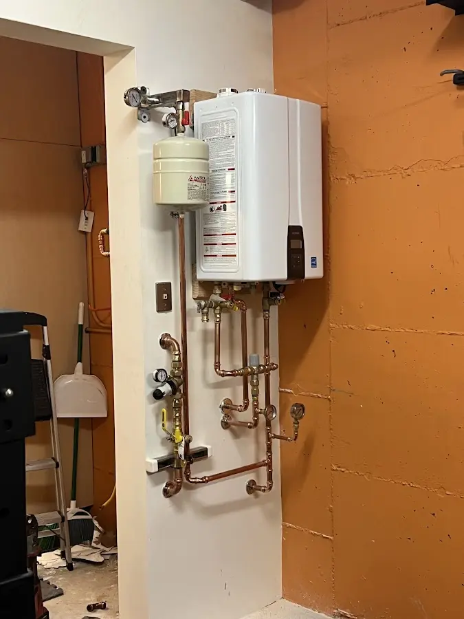 Plumbing technician inspecting water heater connections in Bensenville